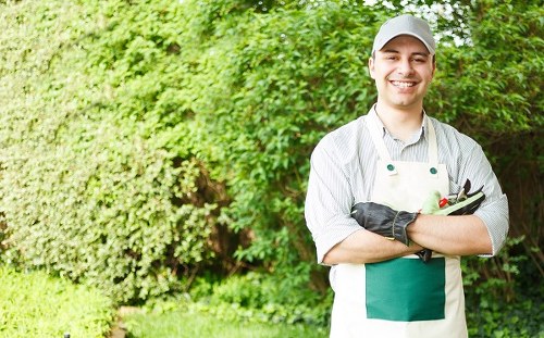 Worker wearing protective gear using gardening equipment